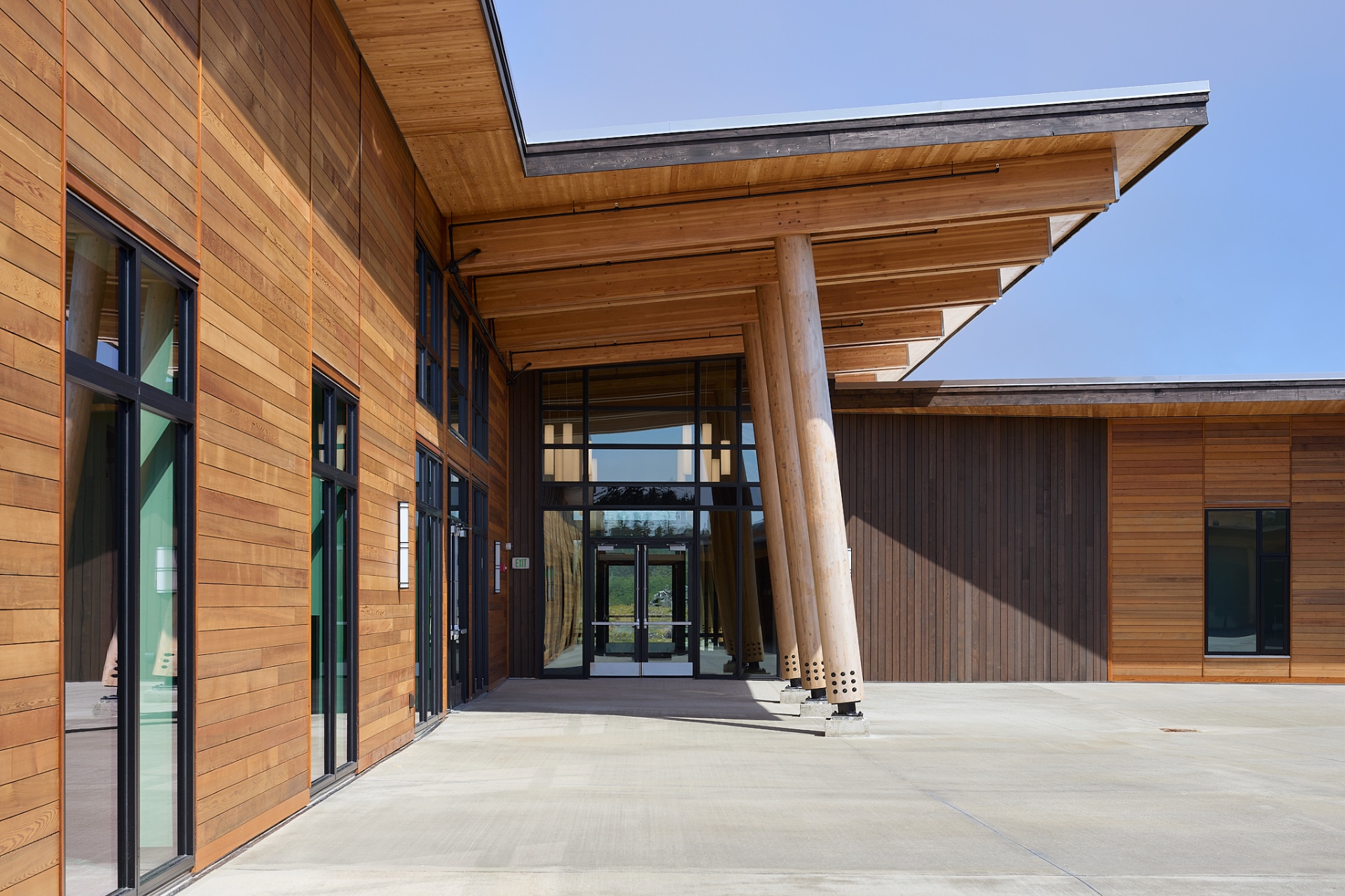 Glazed entry framed by mass timber posts and overhanging eave
